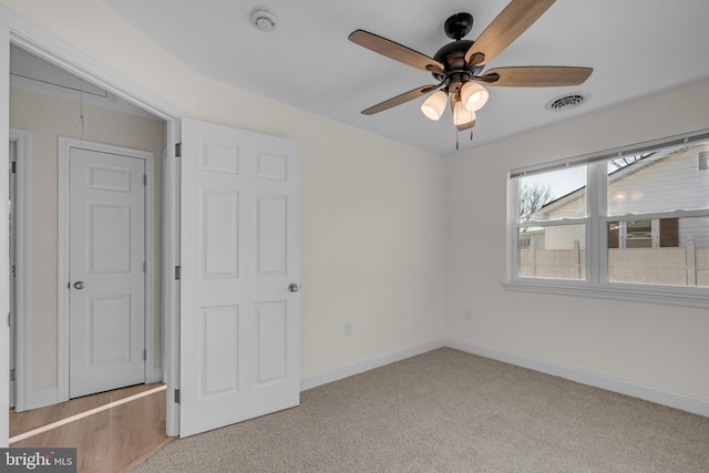 unfurnished bedroom with light carpet, visible vents, attic access, and baseboards