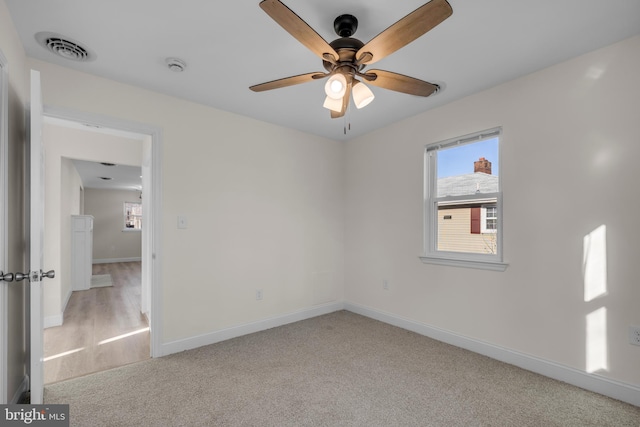 empty room featuring baseboards, visible vents, carpet floors, and a healthy amount of sunlight