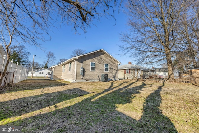 view of side of property featuring cooling unit, a residential view, a lawn, and fence