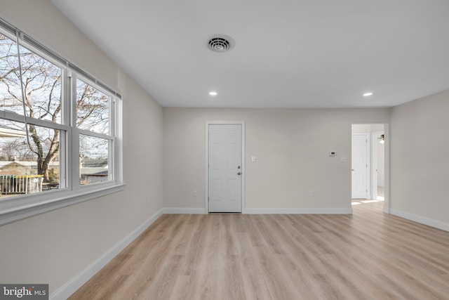 empty room featuring visible vents, recessed lighting, light wood-type flooring, and baseboards