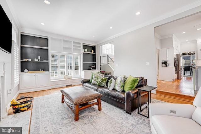 living area featuring recessed lighting, light wood-type flooring, crown molding, and stairway