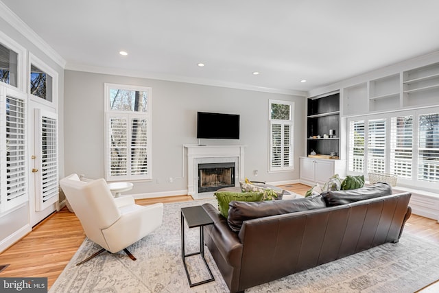 living room featuring ornamental molding, recessed lighting, light wood-type flooring, and a premium fireplace