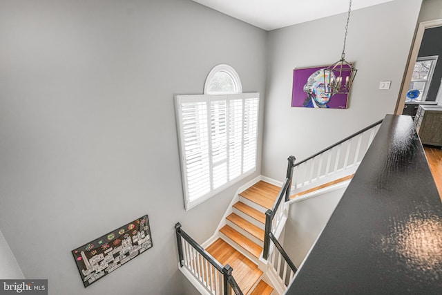 staircase featuring baseboards and wood finished floors