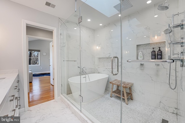 full bath featuring a marble finish shower, visible vents, a freestanding tub, marble finish floor, and vanity