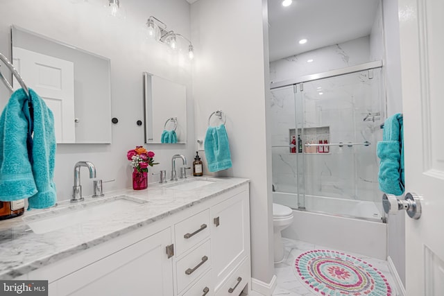 bathroom with double vanity, toilet, marble finish floor, and a sink