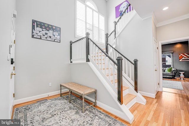 stairs with recessed lighting, baseboards, wood finished floors, and ornamental molding