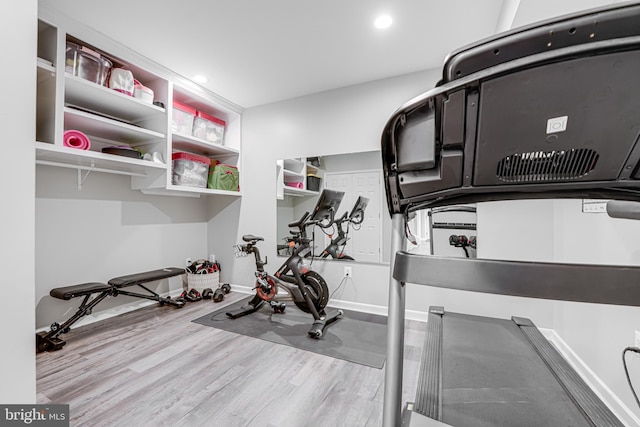 workout room with recessed lighting, baseboards, and wood finished floors