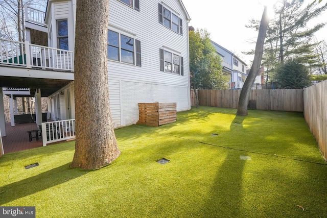 view of yard featuring a balcony and a fenced backyard