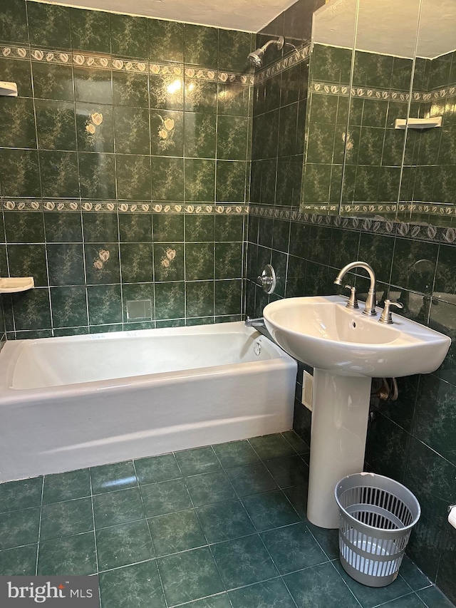 full bath with tile patterned flooring, tile walls, and shower / bath combination