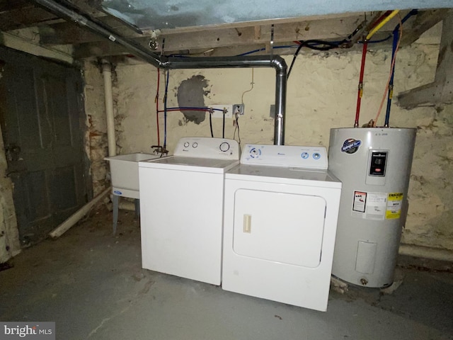 clothes washing area featuring a sink, separate washer and dryer, water heater, and laundry area