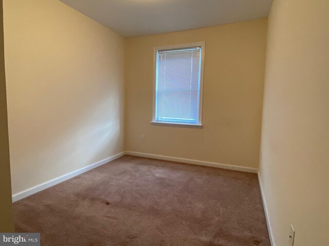 unfurnished room featuring carpet flooring and baseboards