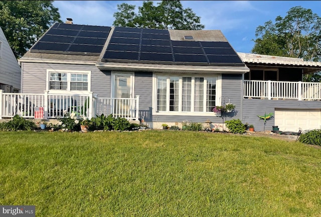 rear view of property with roof mounted solar panels and a yard