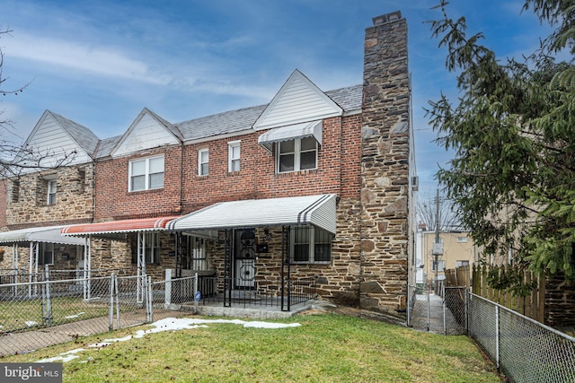 view of front of home featuring a gate, fence, a front lawn, stone siding, and brick siding