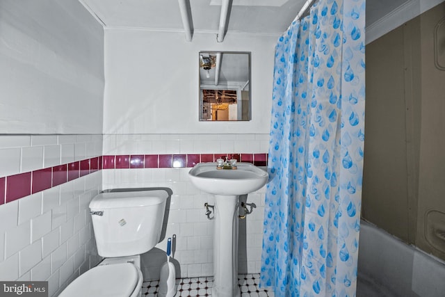 full bath featuring toilet, tile walls, shower / tub combo, and a sink