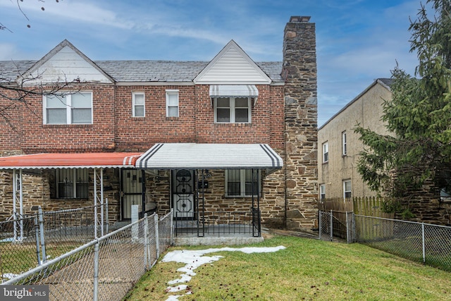 view of front of home featuring a front lawn, fence private yard, brick siding, and stone siding