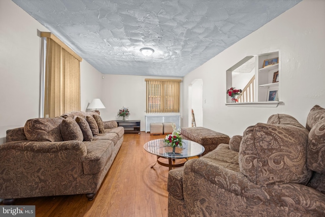 living room featuring a textured ceiling and wood finished floors