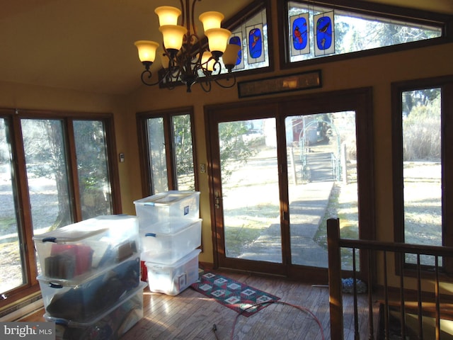 sunroom with an inviting chandelier and lofted ceiling