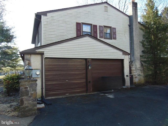 exterior space featuring aphalt driveway and an attached garage