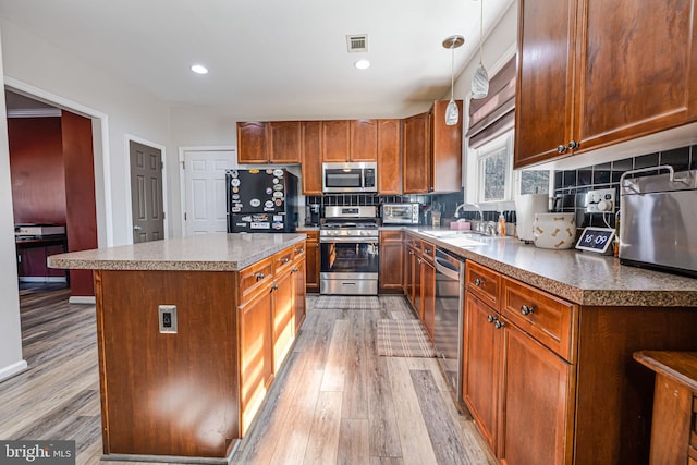 kitchen featuring a sink, light wood-style flooring, visible vents, and stainless steel appliances