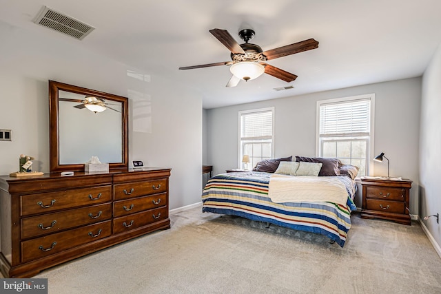 bedroom featuring visible vents, light carpet, and baseboards