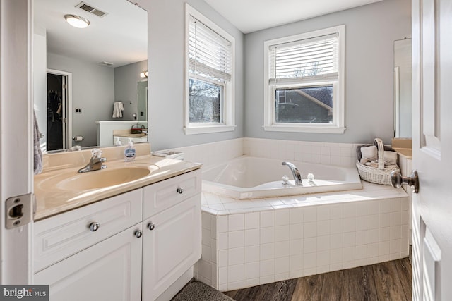 bathroom featuring visible vents, vanity, a garden tub, and wood finished floors