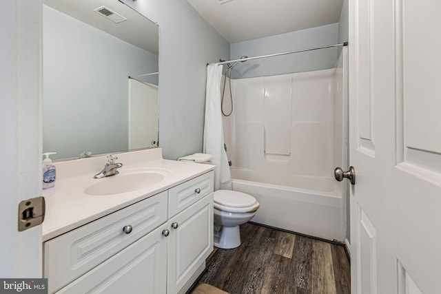 bathroom with visible vents, toilet, wood finished floors, shower / bath combination with curtain, and vanity