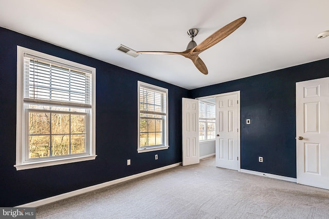 spare room featuring visible vents, baseboards, carpet, and a ceiling fan