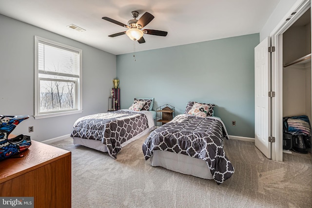 carpeted bedroom with visible vents, baseboards, and a ceiling fan