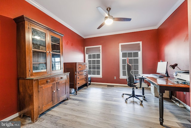 office space with baseboards, light wood-style flooring, a ceiling fan, and crown molding