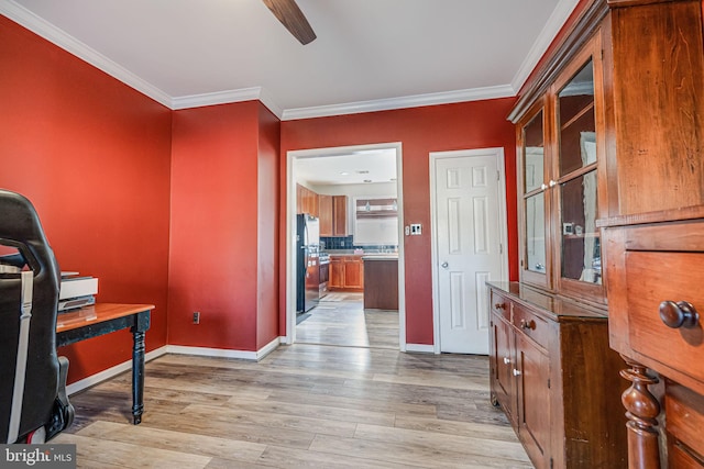 home office with crown molding, light wood-style flooring, a ceiling fan, and baseboards