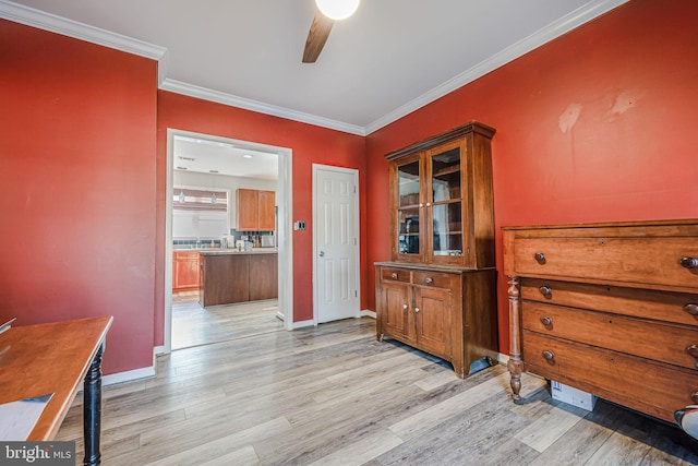 hall with light wood-type flooring, baseboards, and crown molding