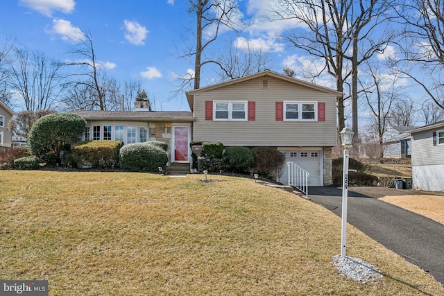 split level home with driveway, entry steps, a front lawn, a garage, and stone siding