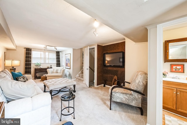 living room with stairs, rail lighting, and light colored carpet