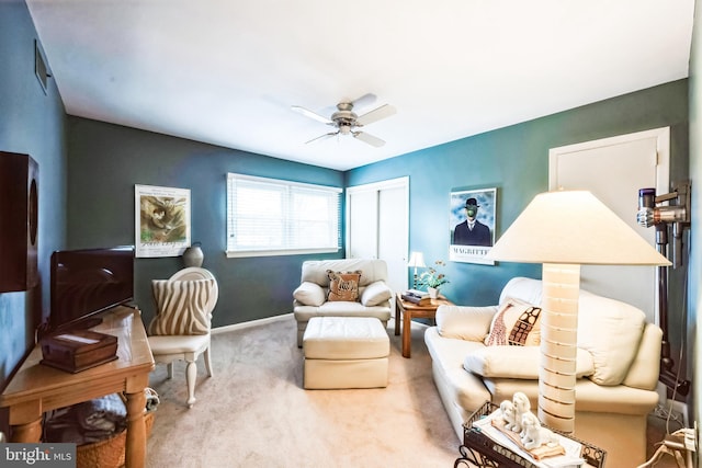 living area featuring carpet flooring, baseboards, and ceiling fan