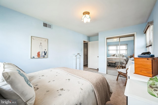 bedroom featuring a closet, visible vents, and light colored carpet