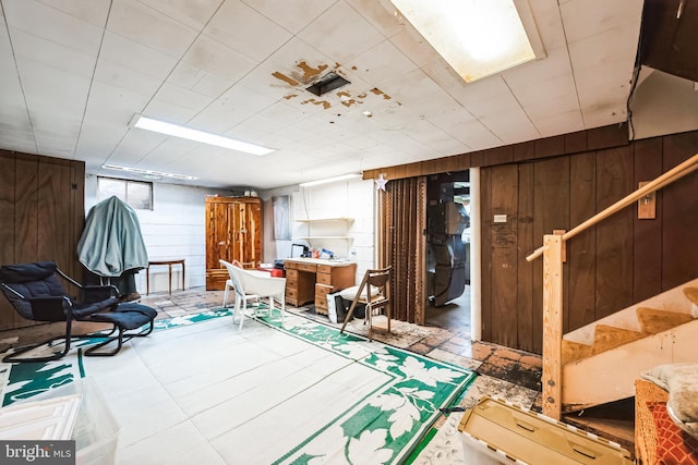 basement with stairs and wood walls