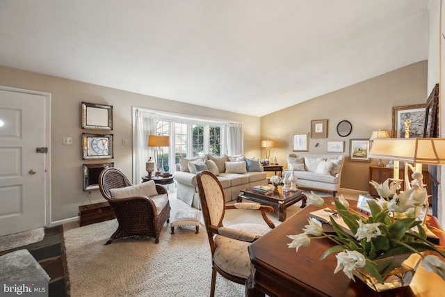 living area with baseboards, lofted ceiling, and carpet floors