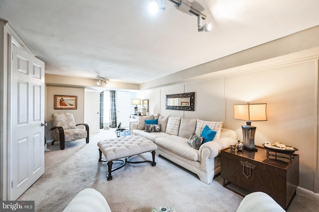 living area with carpet flooring and track lighting