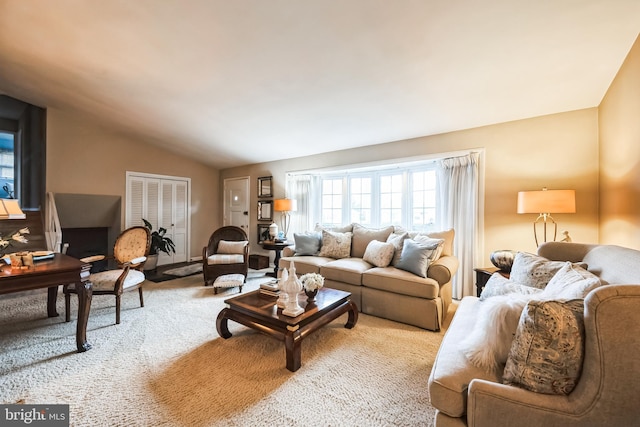 carpeted living area with lofted ceiling