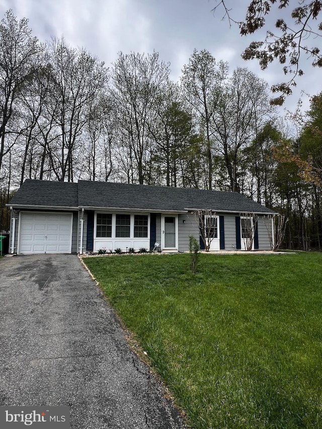 ranch-style house with aphalt driveway, a garage, and a front lawn
