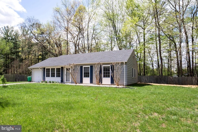 ranch-style house featuring a front yard, a shingled roof, fence, and an attached garage