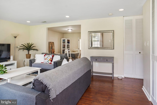 living area with dark wood-type flooring, visible vents, and recessed lighting