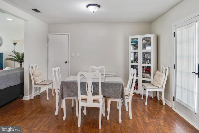 dining space featuring visible vents, baseboards, and dark wood finished floors