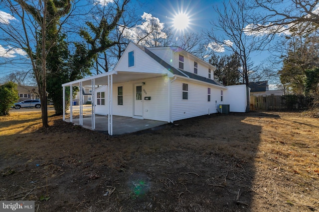 view of property exterior with a patio area, central AC unit, a carport, and fence