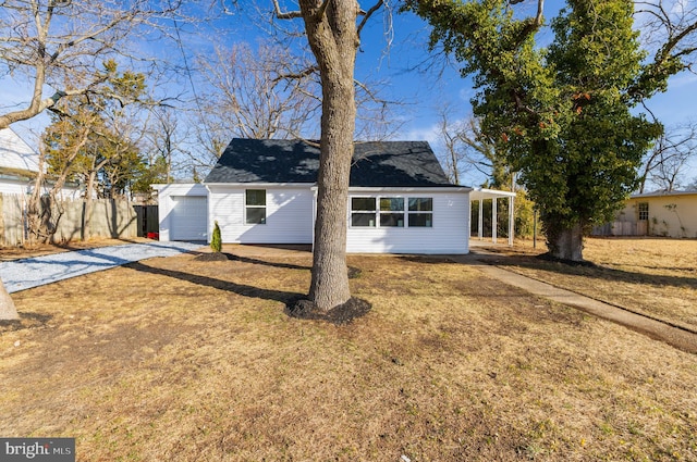 view of front of home featuring driveway, a front yard, and fence