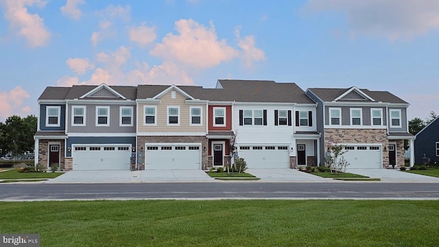 view of property with stone siding, a front yard, and driveway