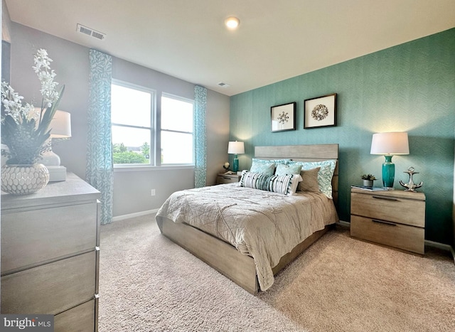 carpeted bedroom featuring visible vents and baseboards