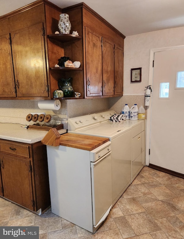 laundry room featuring cabinet space, stone finish floor, and washing machine and clothes dryer