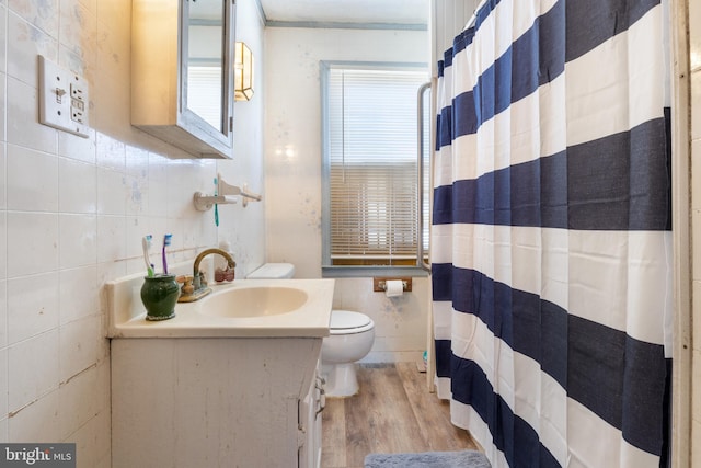 full bathroom with curtained shower, toilet, vanity, wood finished floors, and tile walls