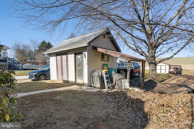 exterior space featuring an attached carport, an outbuilding, and a storage shed